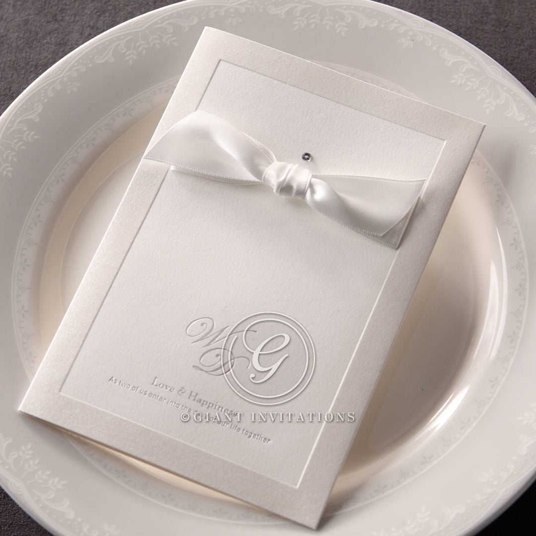 Lightly textured white insert paper attached to a stunning card cover with embossed pearlised border, adorned with a silky bow and sparkling jewel
